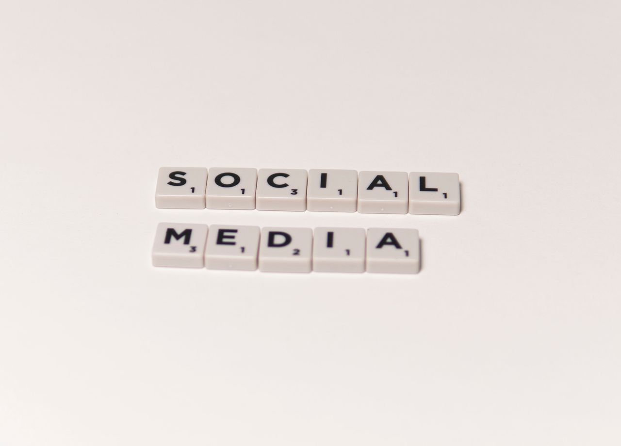 home-hero-bg Scrabble tiles arranged to spell social media against a white backdrop, illustrating ideas of digital communication.