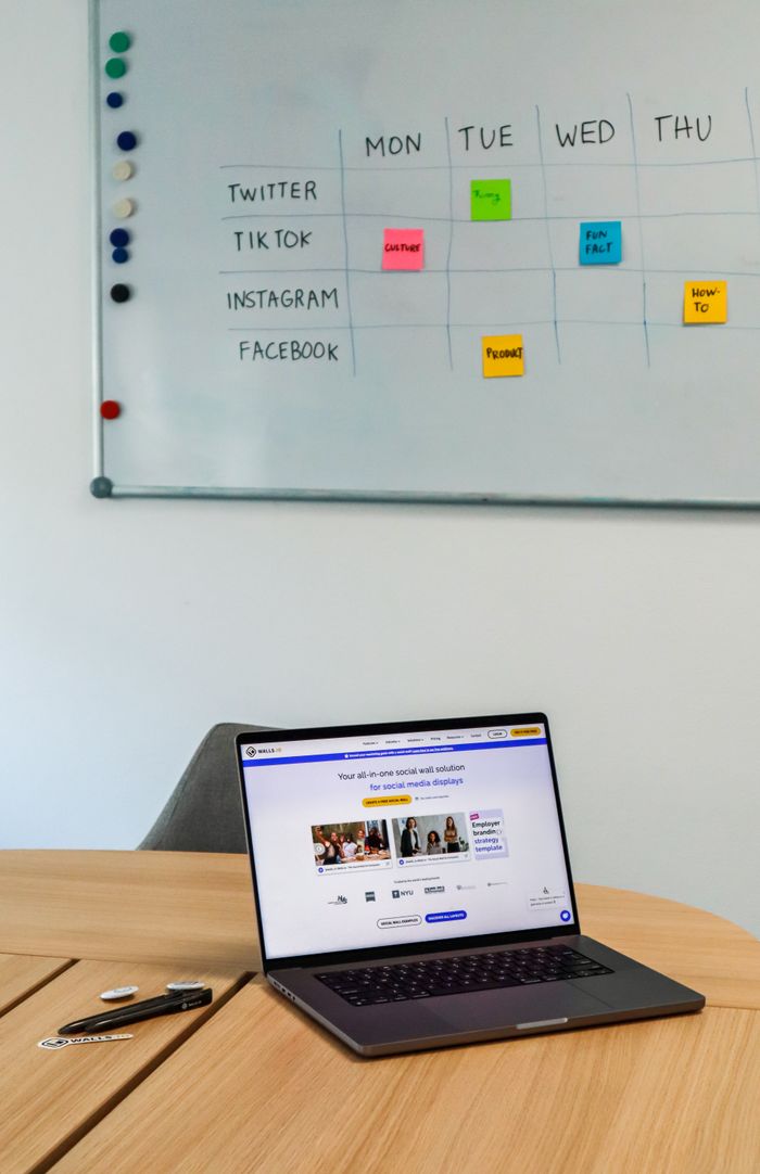 home-services-01 A sleek office arrangement with a laptop and a whiteboard calendar for social media platforms.
